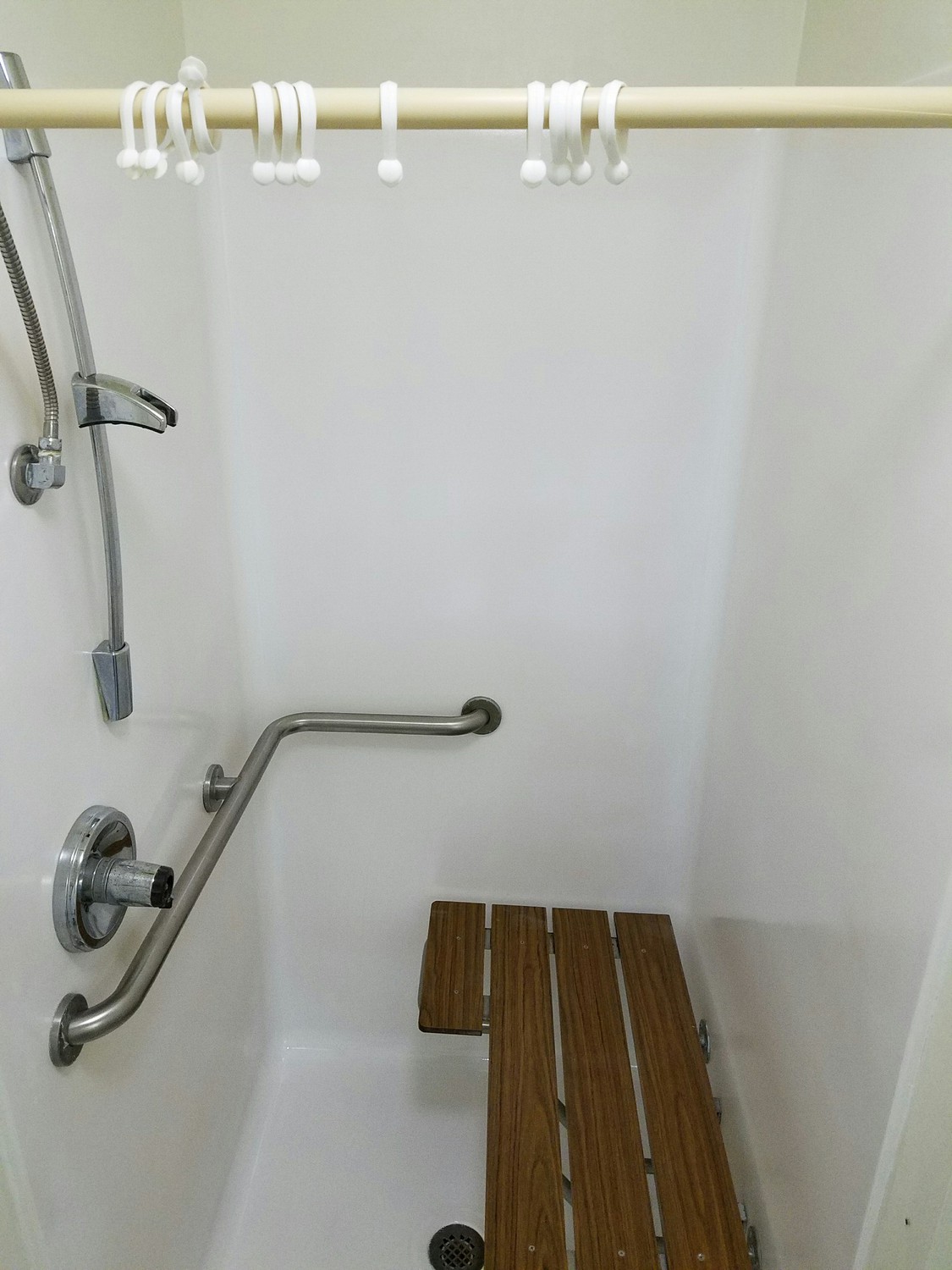 Fiberglass handicapped shower with fiberglass rebuilt shower pan that was repaired, coated, and refinished